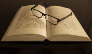 Ein aufgeschlagenes Buch mit einer Brille drauf